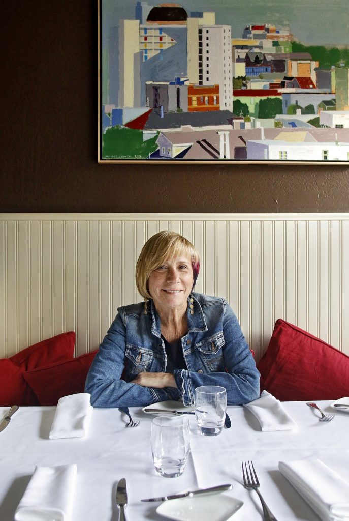 Jesse Ziff Cool sits in a booth in her restaurant, Flea St. Café, which she has operated for the past 36 years in Menlo Park. Photo by Veronica Weber.