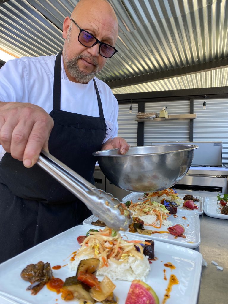 Chef Jose Luis plating a dish with tongs.