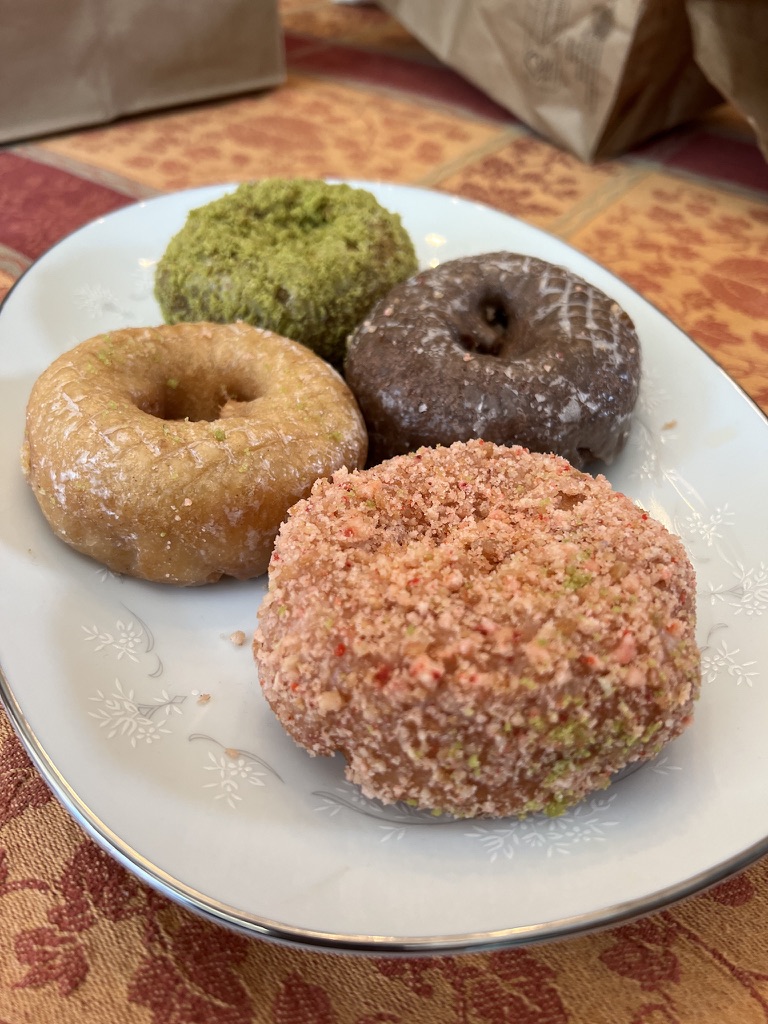 Clockwise from top: matcha crumb, ube glazed, strawberry rose crumb and apple cider glazed doughnuts from Apple Fritter in San Mateo.